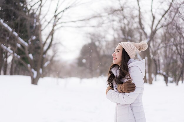Schönes junges asiatisches Frauenlächeln glücklich für Reise in der Schneewintersaison