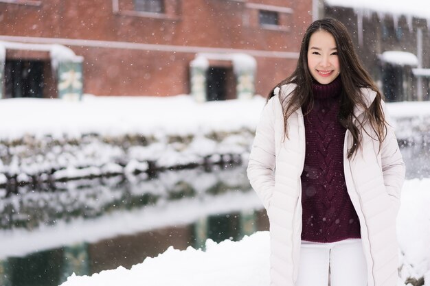 Schönes junges asiatisches Frauenlächeln und glücklich mit Reisereise in Otaru-Kanal Hokkaido Japan