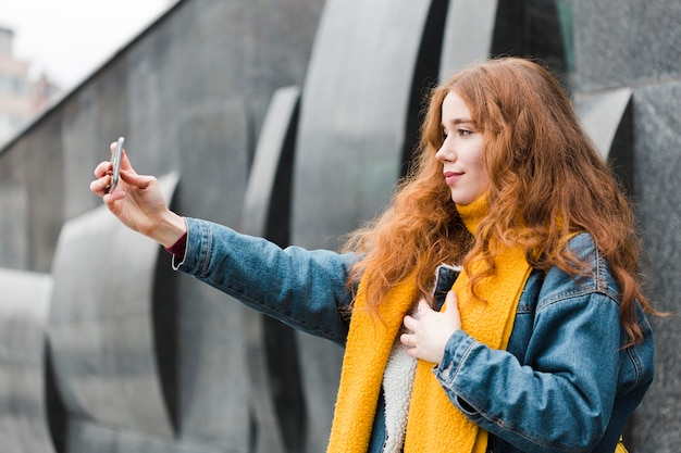 Kostenloses Foto schönes junges mädchen, das ein selfie nimmt