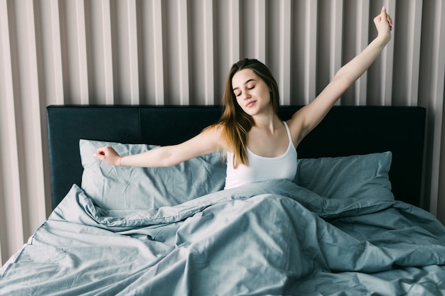 Schönes junges Mädchen, das im Bett liegt