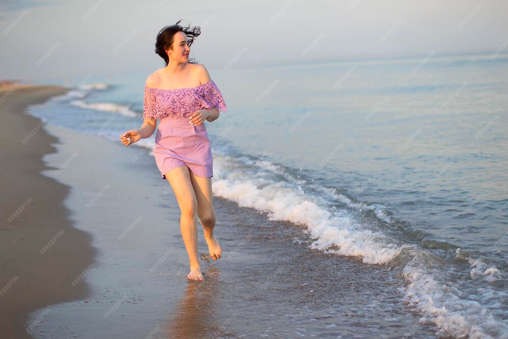 Schönes junges mädchen läuft am meer entlang. gewöhnliches