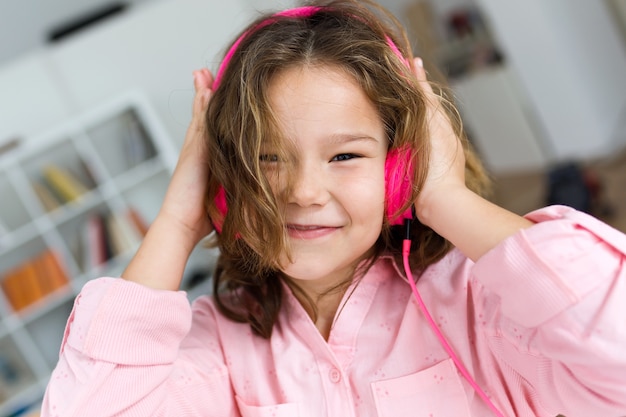Schönes Kind hört Musik und tanzt zu Hause.