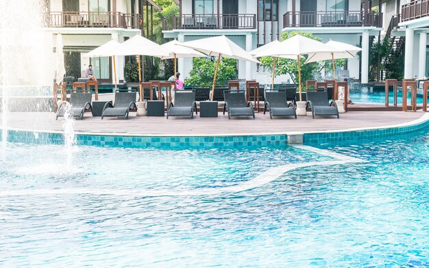 Schönes Luxushotel Schwimmbad Resort mit Sonnenschirm und Stuhl