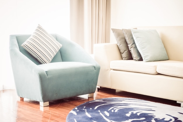 Schönes Luxuskissen auf Sofadekoration im Wohnzimmerinnenraum - Weinlese-Licht-Filter