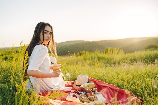 Schönes Mädchen auf einem Picknick im Sommerfeld