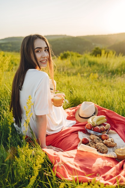 Schönes Mädchen auf einem Picknick im Sommerfeld