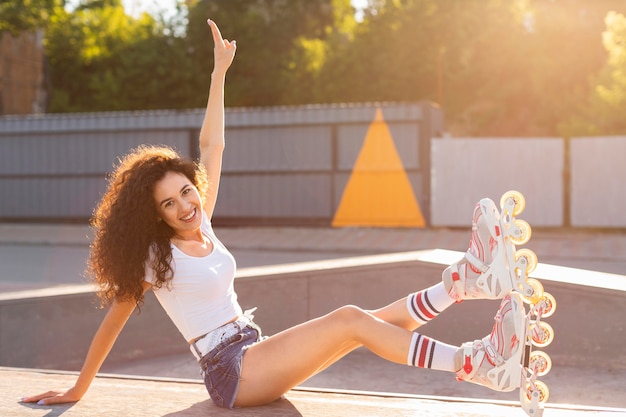 Schönes Mädchen, das im Rollerblades draußen aufwirft