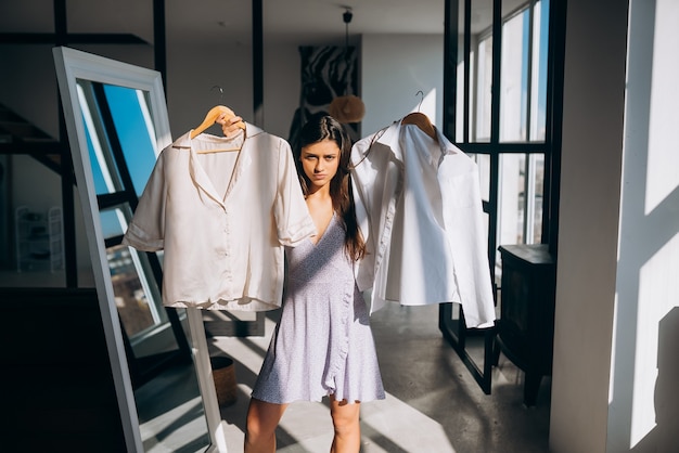 Schönes Mädchen, das Kleid im Zimmer anprobiert