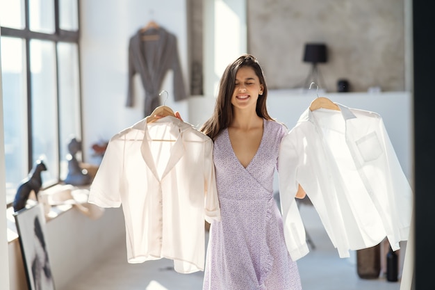 Kostenloses Foto schönes mädchen, das kleid im zimmer anprobiert