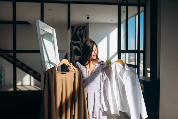 Schönes Mädchen, das Kleid im Zimmer anprobiert