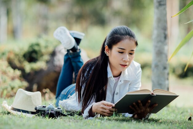 Schönes Mädchen im Herbstwald ein Buch lesend