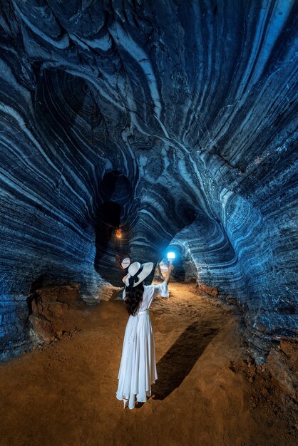 Schönes Mädchen im weißen Kleid, das in der blauen Höhle, Thailand geht