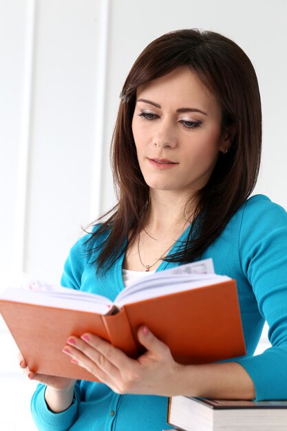 Schönes Mädchen mit blauem T-Shirt und Büchern