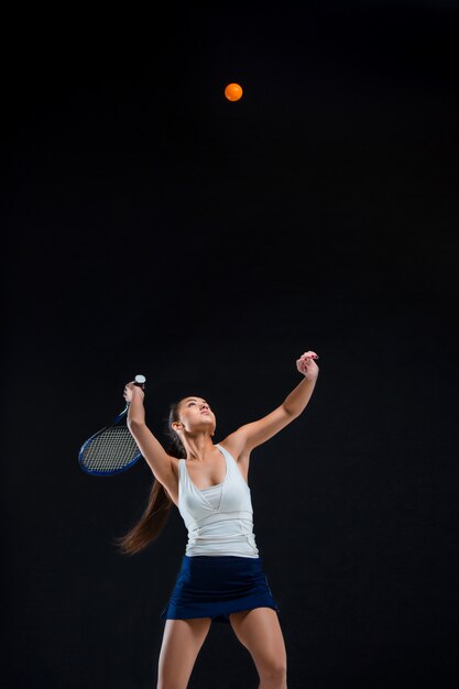 schönes Mädchen Tennisspieler mit einem Schläger auf dunklem Hintergrund