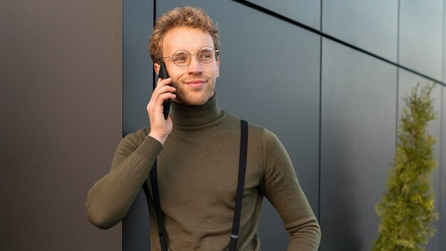 Schönes männliches Modell, das am Telefon spricht