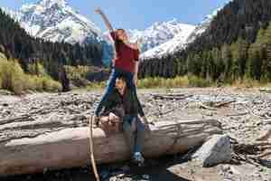 Kostenloses Foto schönes paar des jungen hipsters, das am fluss im wald wandert