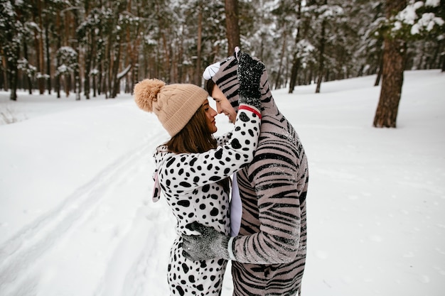 Schönes Paar in coolen Kostümen von Tieren. Paare in der Liebe im Winterwald.