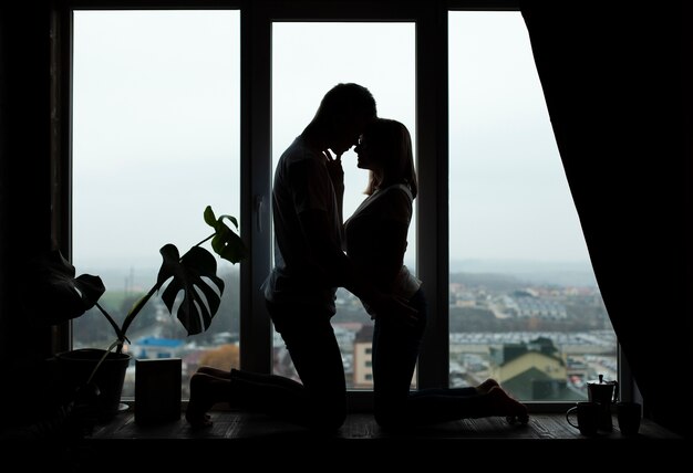 Schönes Paar posiert neben dem Fenster