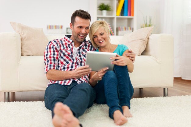 Schönes Paar zu Hause mit Digitalanzeige