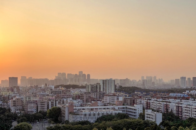 Schönes Panorama der Stadtgebäude unter einem orangefarbenen Himmel bei Sonnenuntergang