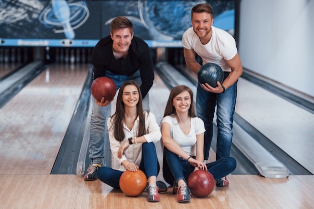 Schönes Porträt. Junge fröhliche Freunde haben an ihren Wochenenden Spaß im Bowlingclub