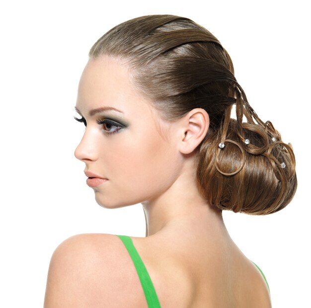 Schönes Teenager-Mädchen mit moderner Frisur, lokalisiert auf Weiß. Profilporträt