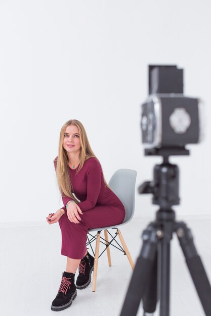 Schönes unscharfes weibliches Modell, das auf einem Stuhl im Studio sitzt