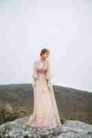 Kostenloses Foto schönes vertikales bild einer ingwerfrau mit einer reinen weißen haut in einem attraktiven rosa kleid