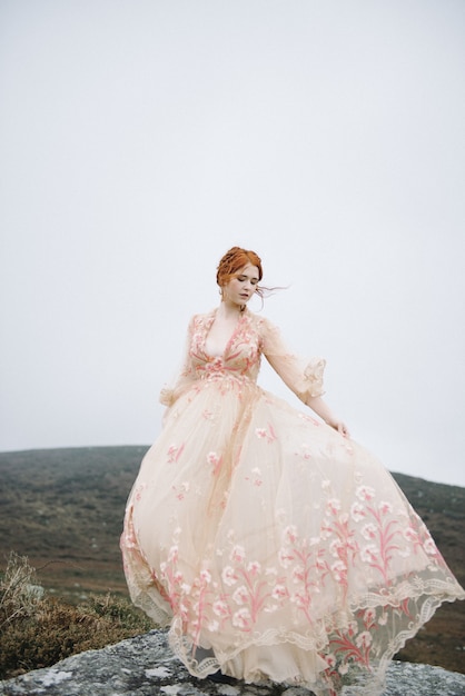 Kostenloses Foto schönes vertikales bild einer ingwerfrau mit einer reinen weißen haut in einem attraktiven rosa kleid