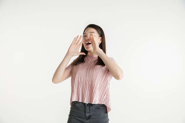 Schönes weibliches Porträt der halben Länge lokalisiert auf weißem Studiohintergrund. Junge emotionale Frau in Freizeitkleidung. Menschliche Emotionen, Gesichtsausdruckkonzept. Erstaunt, verwundert, nach Verkäufen verlangend.