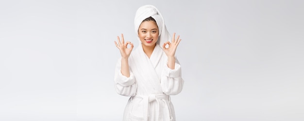 Schönheit asiatische Frau ok Geste für gutes Gesichtsprodukt isoliert auf weißem Hintergrund Schönheits- und Modekonzept