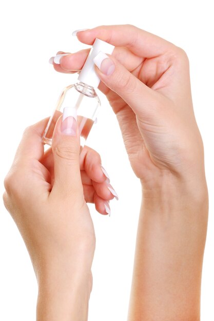 Schönheit gut gepflegte weibliche Hand halten die Flasche eines Nagels verschwinden über
