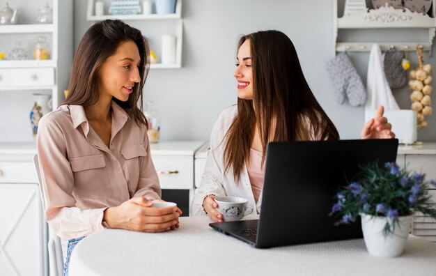 Schönheiten, die vom Haus an Laptop arbeiten