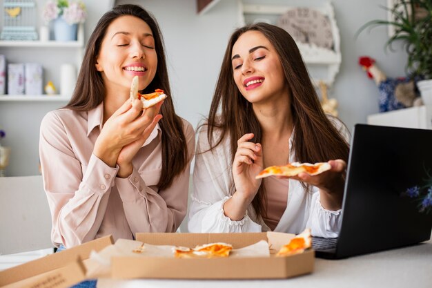 Schönheiten, die zu Hause Pizza essen