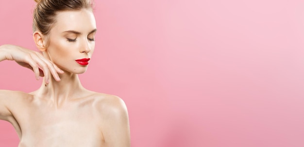 Kostenloses Foto schönheitskonzept nahaufnahme wunderschöne junge brünette frau gesicht porträt beauty model girl mit hellen augenbrauen perfektes make-up rote lippen berühren ihr gesicht isoliert auf rosa hintergrund