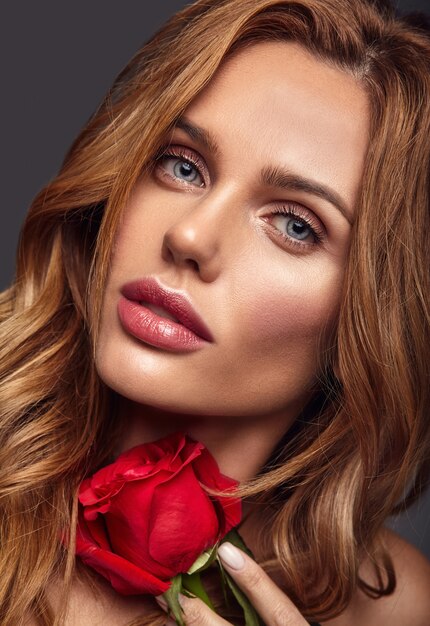 Schönheitsmodeporträt des jungen blonden Frauenmodells mit natürlichem Make-up und perfekter Haut mit der schönen Rosenaufstellung