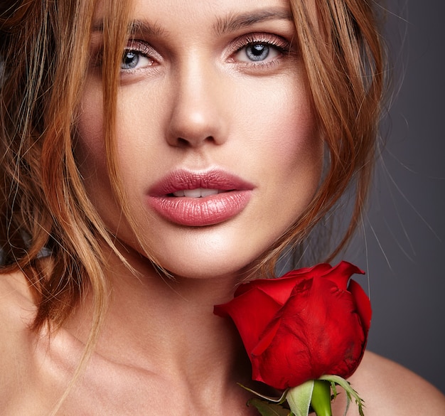 Schönheitsmodeporträt des jungen blonden Frauenmodells mit natürlichem Make-up und perfekter Haut mit der schönen Rosenaufstellung