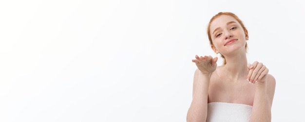 Kostenloses Foto schönheitsporträt einer lächelnden jungen frau mit blick in die kamera einzeln auf grauem hintergrund