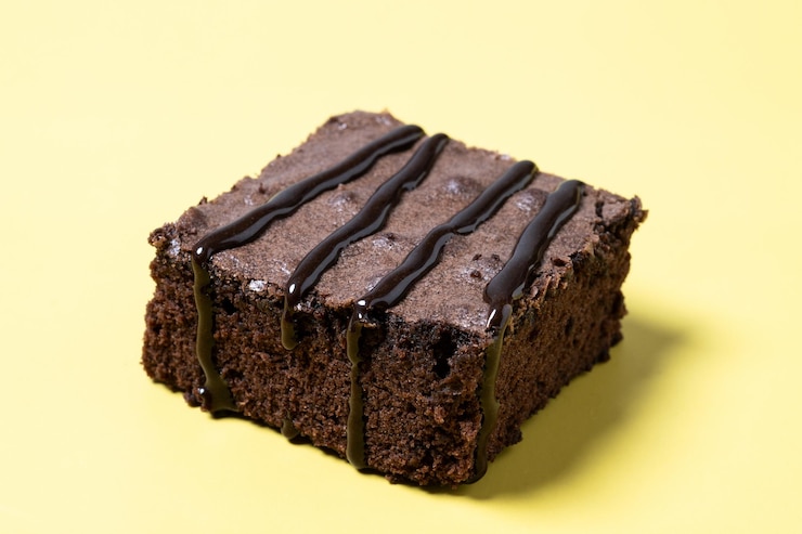 Kostenlose Foto schokoladen-brownie-portion auf gelbem hintergrund