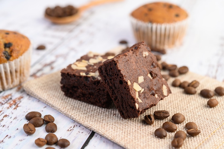 Kostenlose Foto schokoladen-brownies auf sackleinen und kaffeebohnen auf einem holztisch.