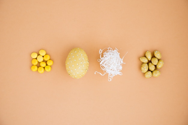 Schokoladen-Ostereier mit kleinen Süßigkeiten auf beige Tabelle