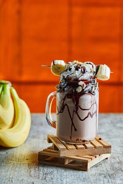 Schokoladen-smoothie mit schokoladensirup und bananenzweig