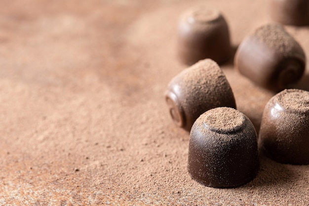 Schokoladenbonbons und Kakaopulver Hintergrund Nahaufnahme