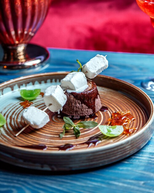 Schokoladenfondant mit Würfeleis auf Holzstäbchenminze-Seitenansicht