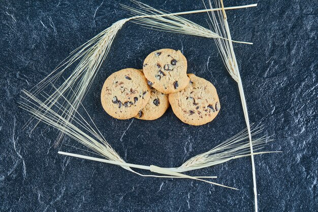 Schokoladenkekse auf einer Marmoroberfläche mit Weizenähren