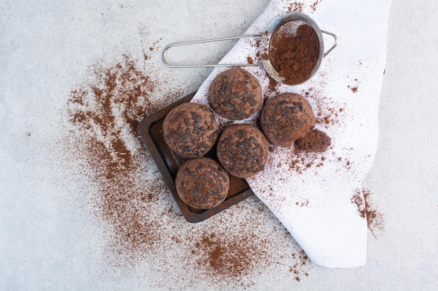 Schokoladenkekse mit Kakaopulver auf Holzplatte. Foto in hoher Qualität