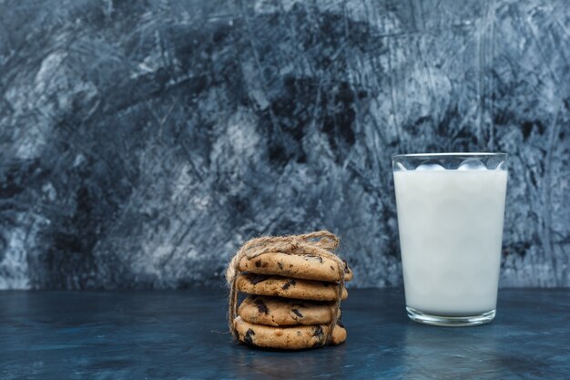 Schokoladenkekse und Milch auf einem dunkelblauen Marmorhintergrund. Nahansicht.