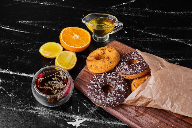 Schokoladenkrapfen auf einem Holzbrett mit Kräutertee