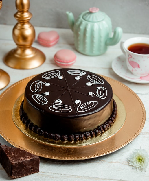 Schokoladenkuchen auf einem Tablett und eine Tasse duftenden Tee