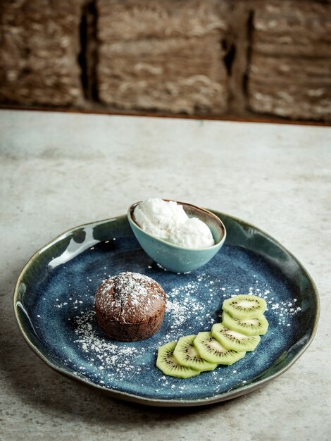 Schokoladenkuchen mit geschnittener Kiwi und Eiscreme